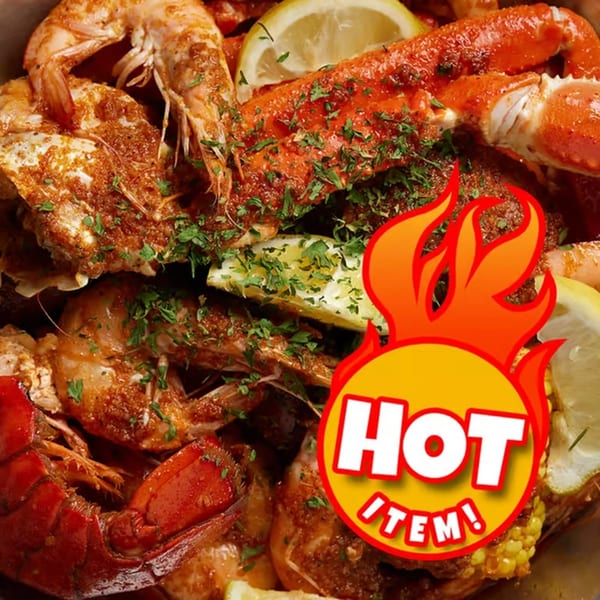 Crab N' Spice seafood boil with shrimp, crab legs, lobster, corn, and lemon slices.