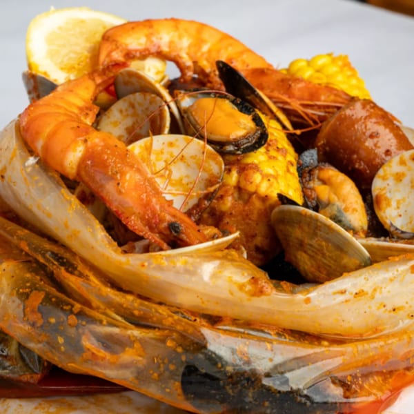 Crab N' Spice seafood boil with shrimp, clams, mussels, corn, and sausage in a bag.
