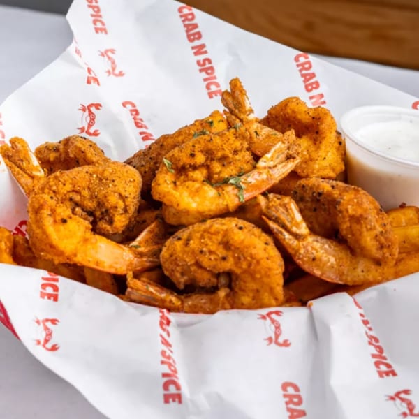 Crab N' Spice fried shrimp seasoned with spices, served with a side of dipping sauce.
